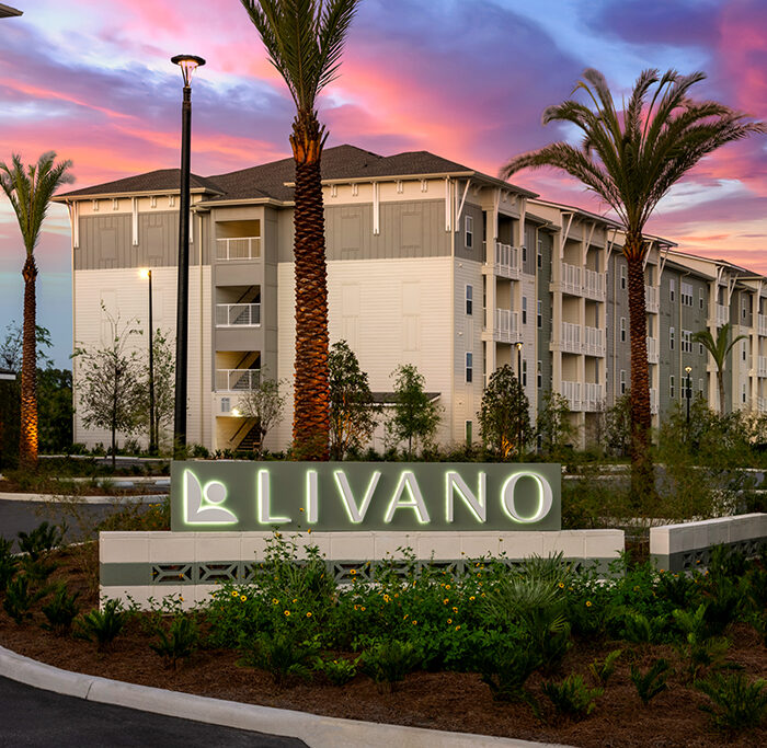 4 story apartment building with sign in front "Livano"