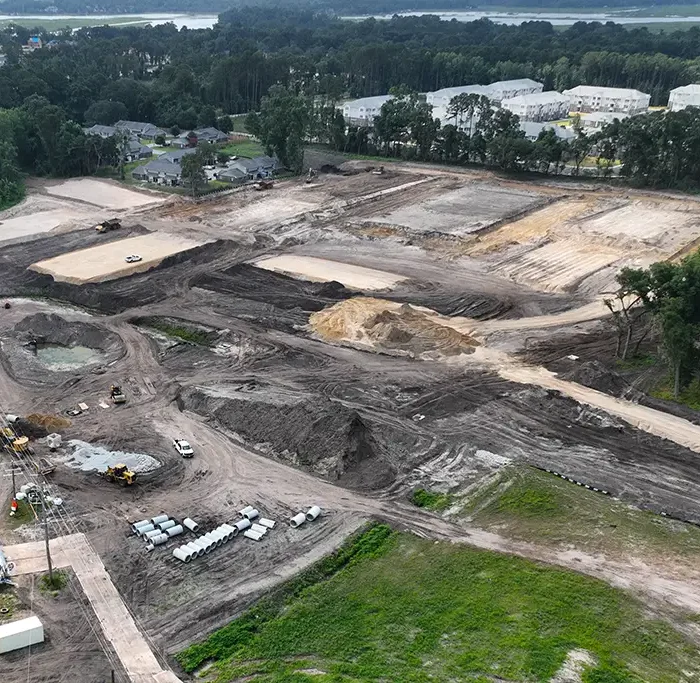 aerial view of a construction site with ground work in progress, setting building pads